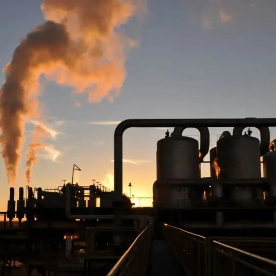 Instalação industrial com emissão de fumaça ao entardecer, representando ambientes de alta exigência para cabos LSZH